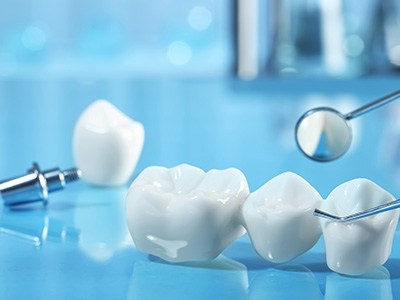 Dental implant and dental bridge parts next to dental tools