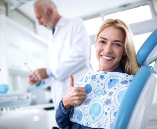 Woman giving thumbs up in tobacco free dental office facility
