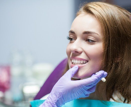 Dentist examining dentistry patient's smile after dental crown restorative dentistry treatment