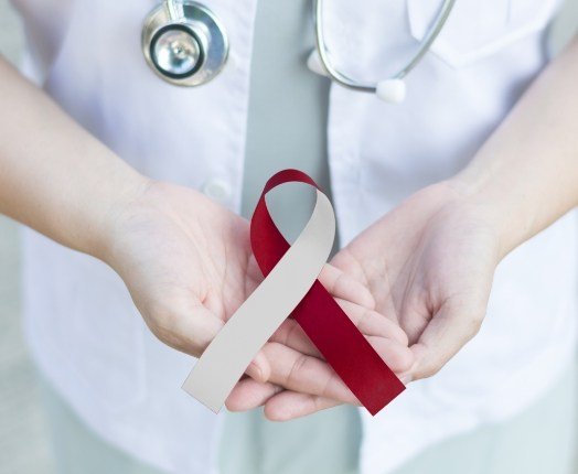 Dentist holding an oral cancer awareness month ribbon