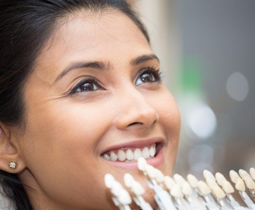 Woman's smile compared with dental bonding color options