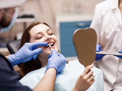 A dentist assessing a woman for cosmetic dental work