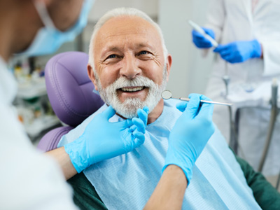 A smiling senior man receiving dental care
