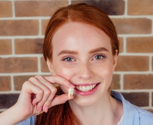 Woman holding tooth after extraction