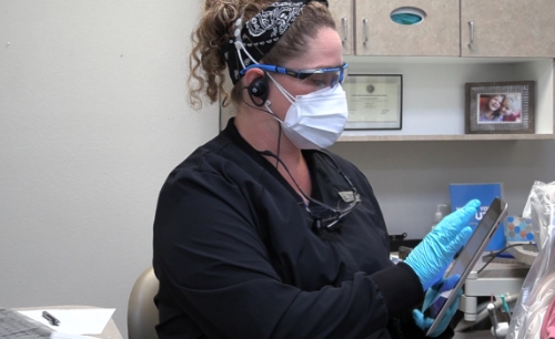 Dental team member reviewing dentistry patient's treatment plan