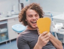 Man looking at some in mirror after preventive dentistry visit