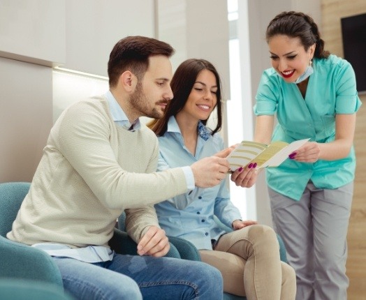 Dental team member and patients discussing how dental insurance works