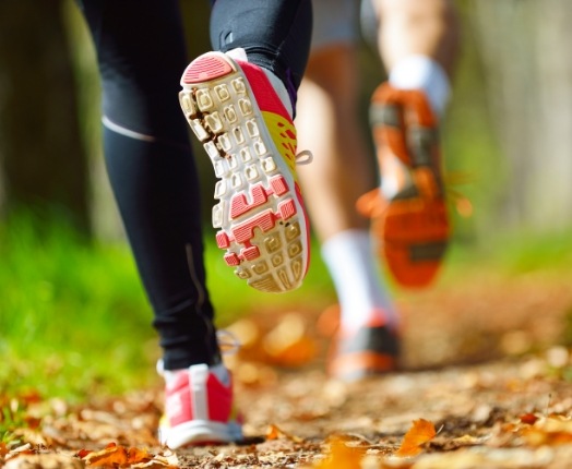 Two people running on a trail