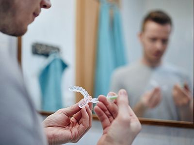 A young man preparing an over-the-counter teeth whitening tray
