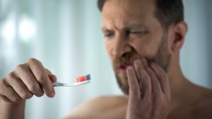 man holding jaw in pain