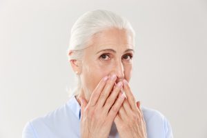 older woman hiding her teeth from dentist in Harker Heights
