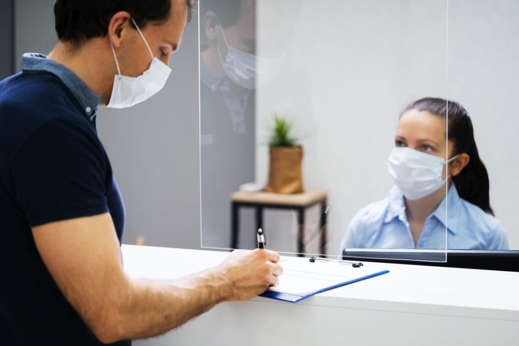 Social distancing with plastic barrier at dentist in Harker Heights