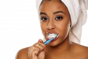 woman smiling cleaning teeth with toothbrush