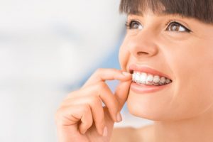 woman inserting Invisalign in Harker Heights  