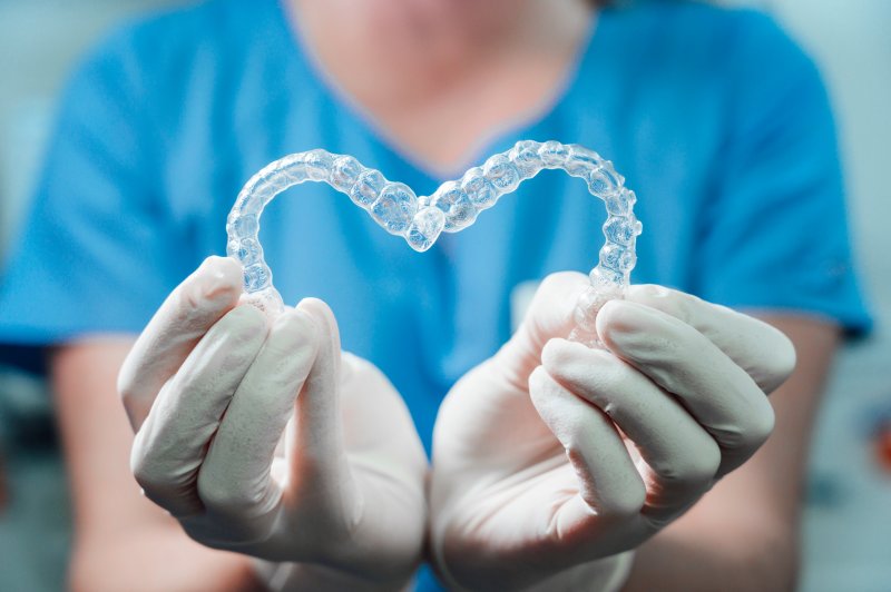 A dentist in Harker Heights holding two Invisalign trays