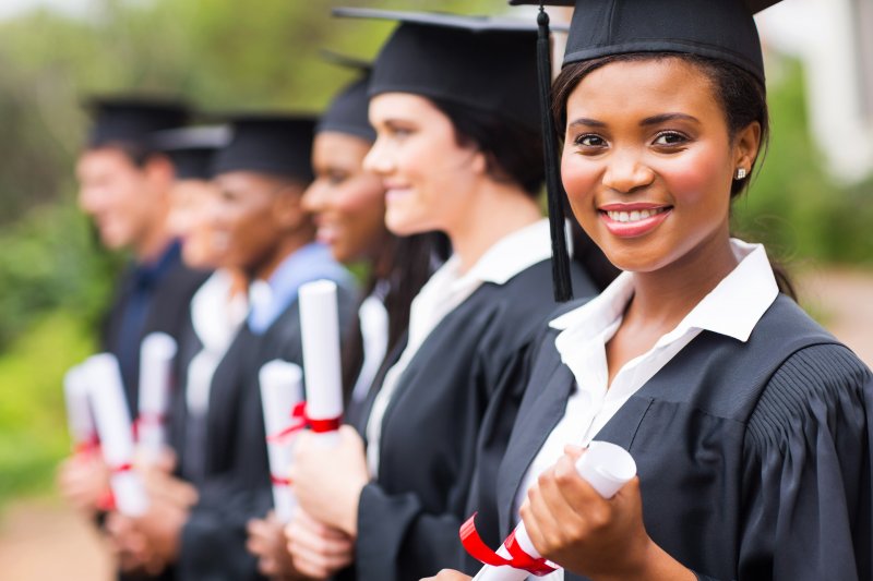 A pretty woman standing alongside other graduating students